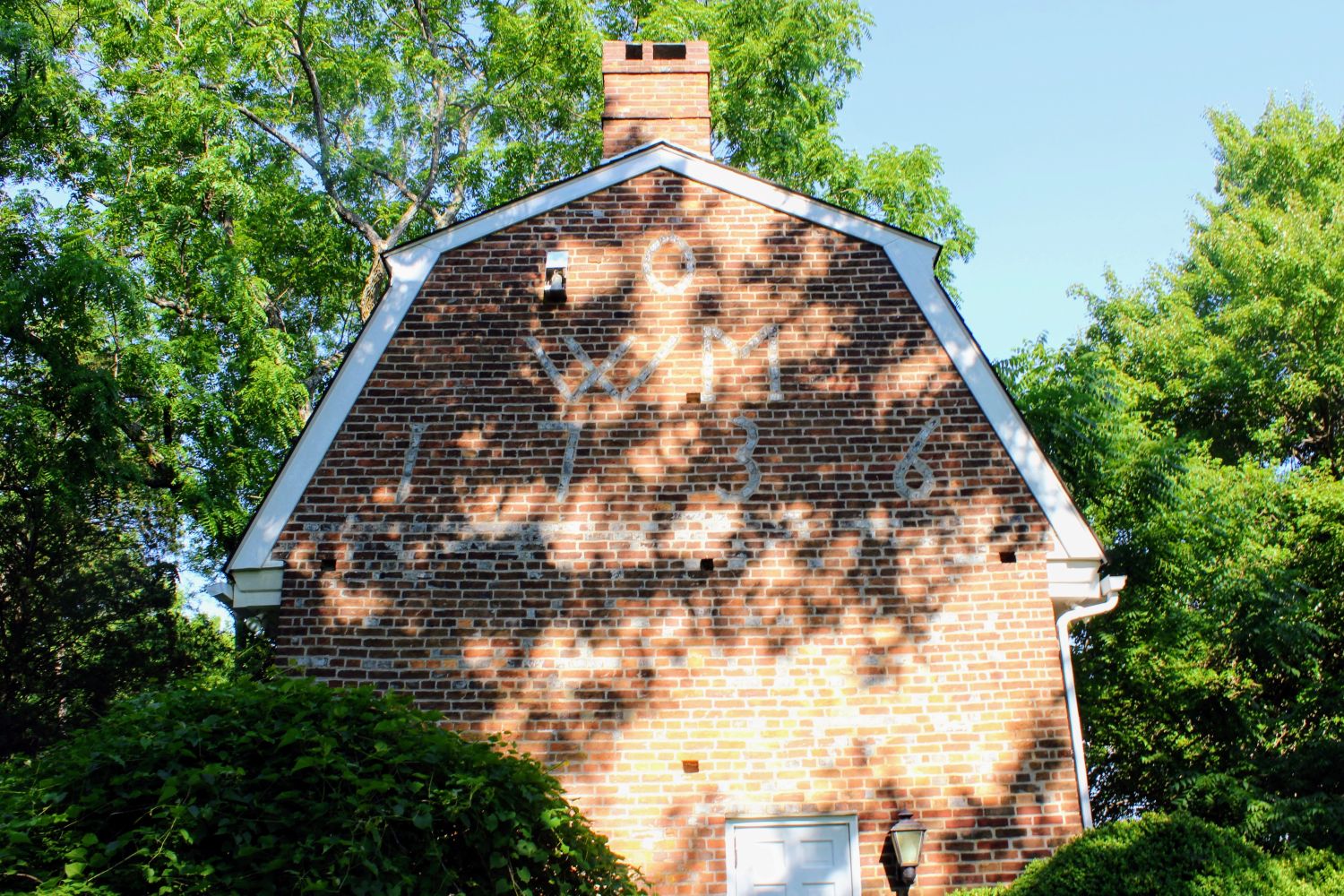 A direct, clear view of the upper west gable, documenting the exact layout of the 1736 Oakford family monogram. This enduring piece of structural history stands exactly as William Oakford intended nearly three centuries ago.