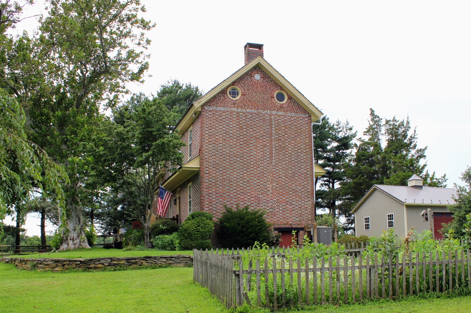 The Jarman House's east gable end, where the vitrified checkering documented in 1949 gives way to plain brick partway up the wall, just as both historical sources described.